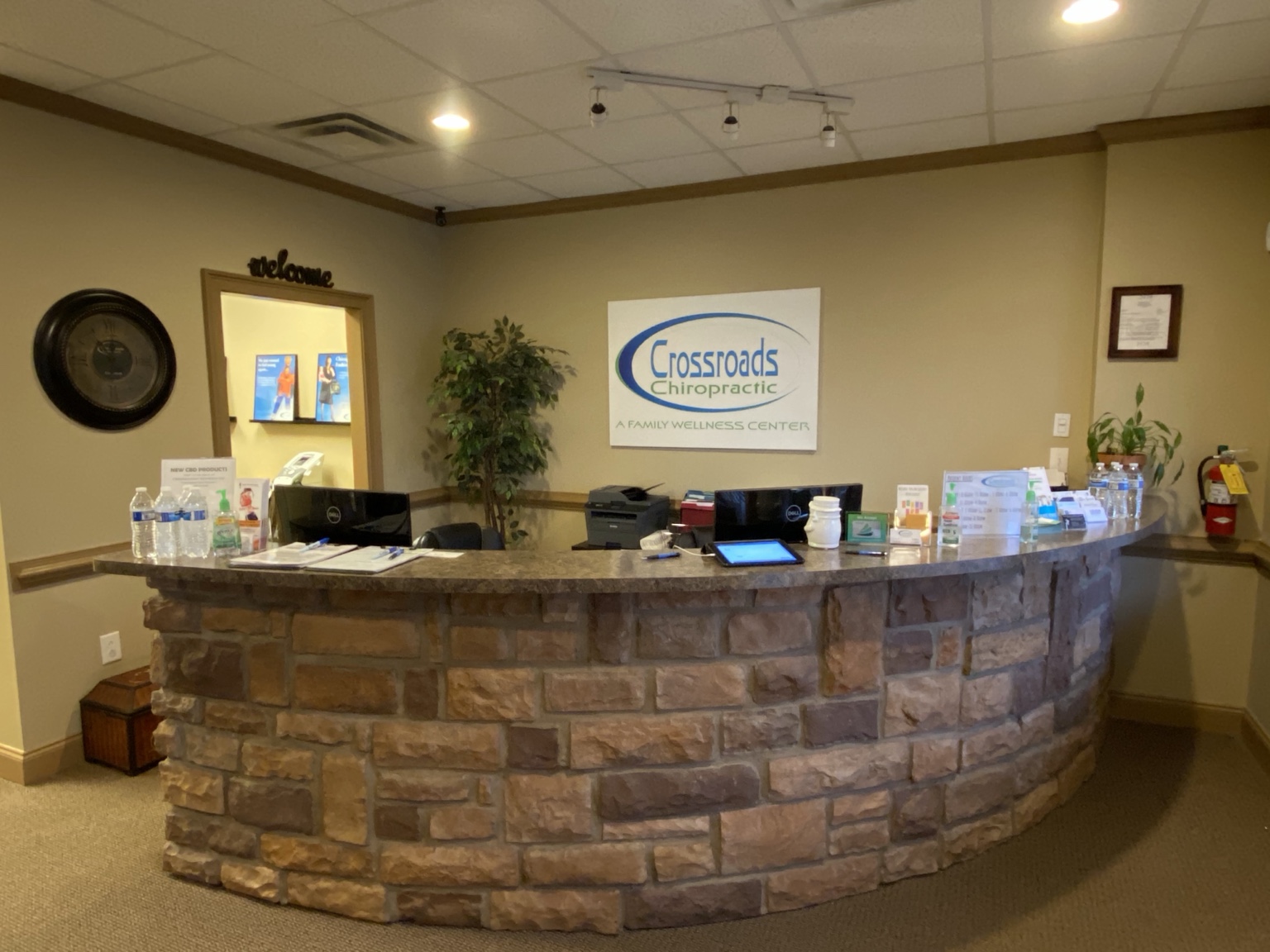 Stone-front reception desk and Crossroads Chiropractic wall sign inside our Sharpsburg office